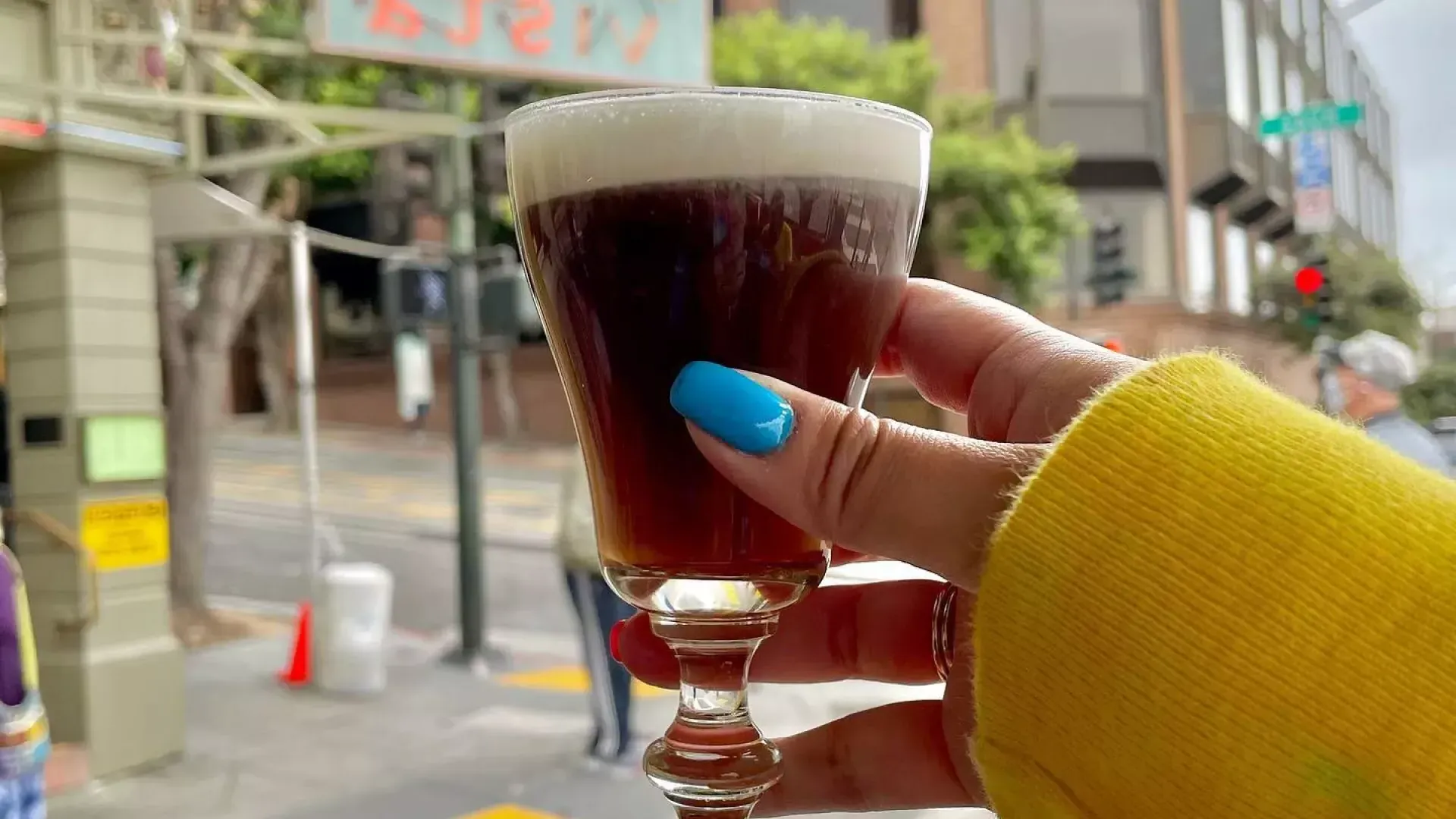 A visitor enjoys an Irish coffee outside the famous Buena Vista Cafe