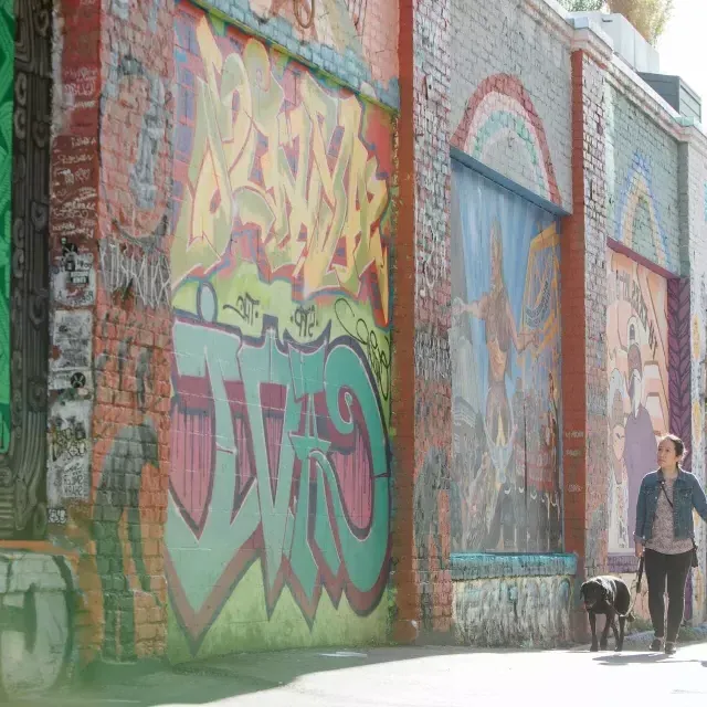 A couple walking down Balmy Alley in the Mission.